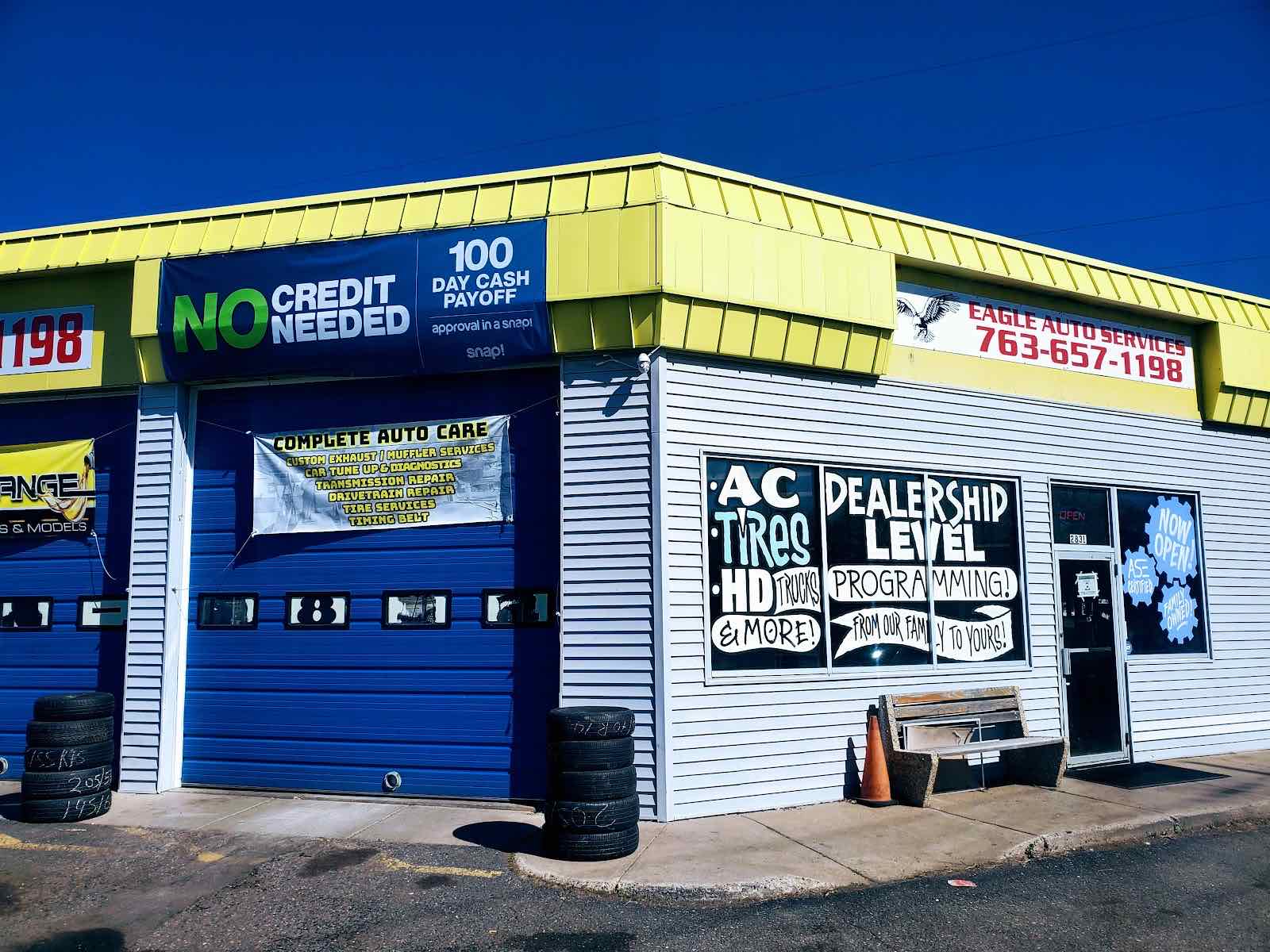 The real Eagle Auto Services storefront on Coon Rapids Blvd, with yellow roof trim and a blue garage door