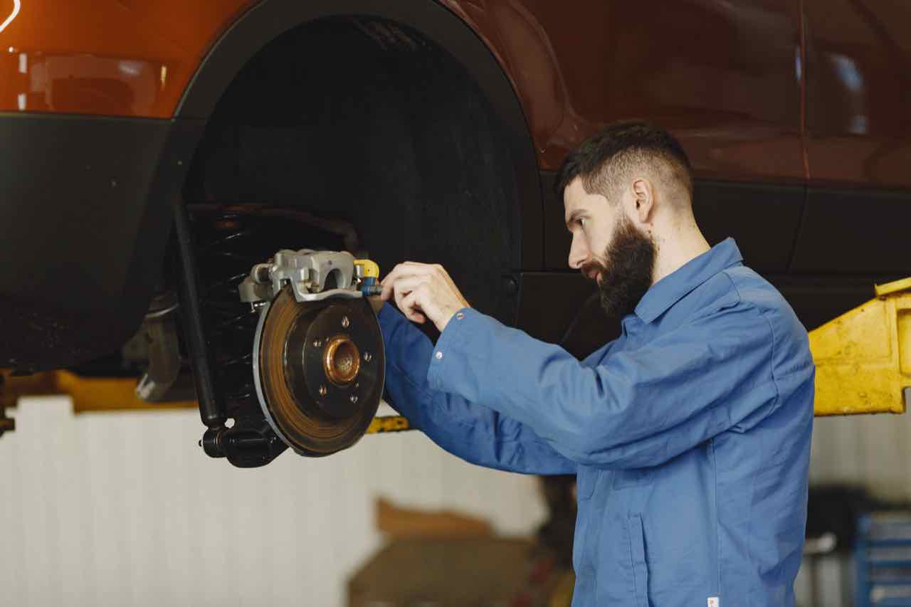 Mechanic inspecting a car's brake rotor and caliper
