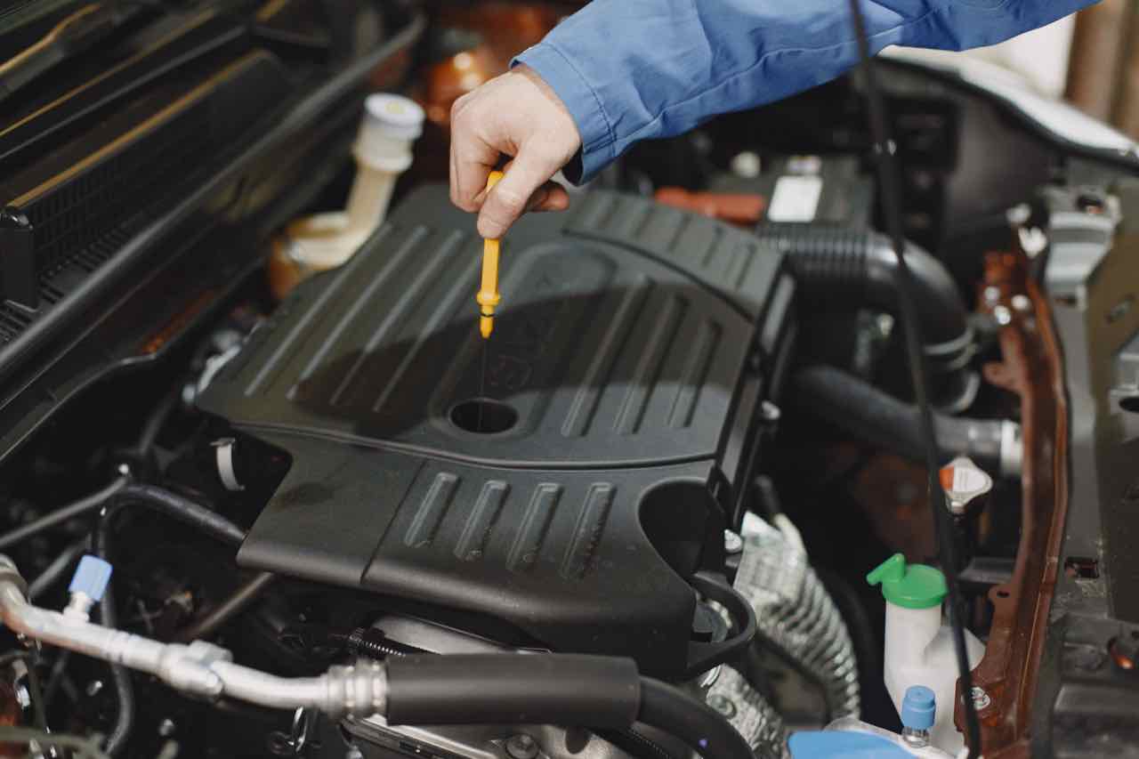 Mechanic checking engine oil level with a dipstick