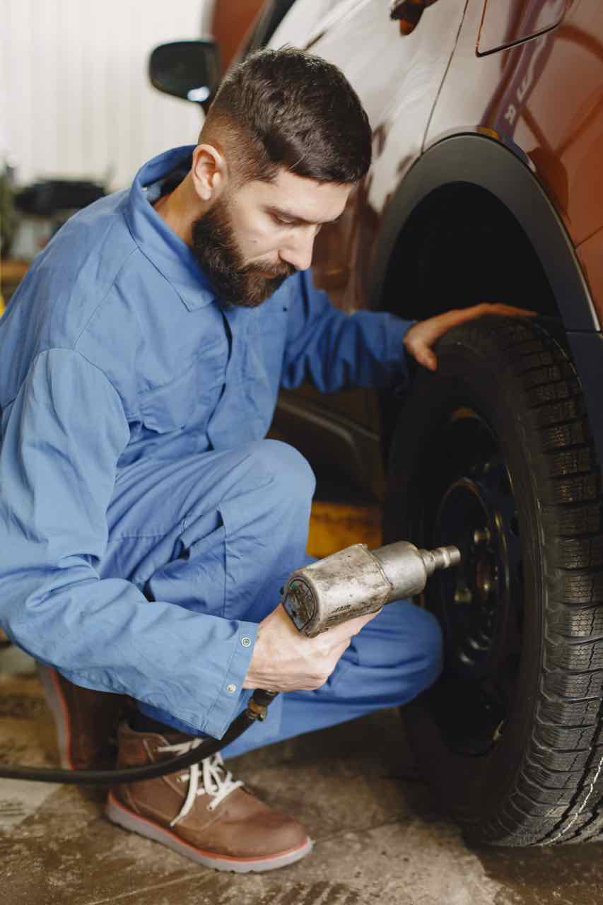 Mechanic using an impact wrench on a car tire